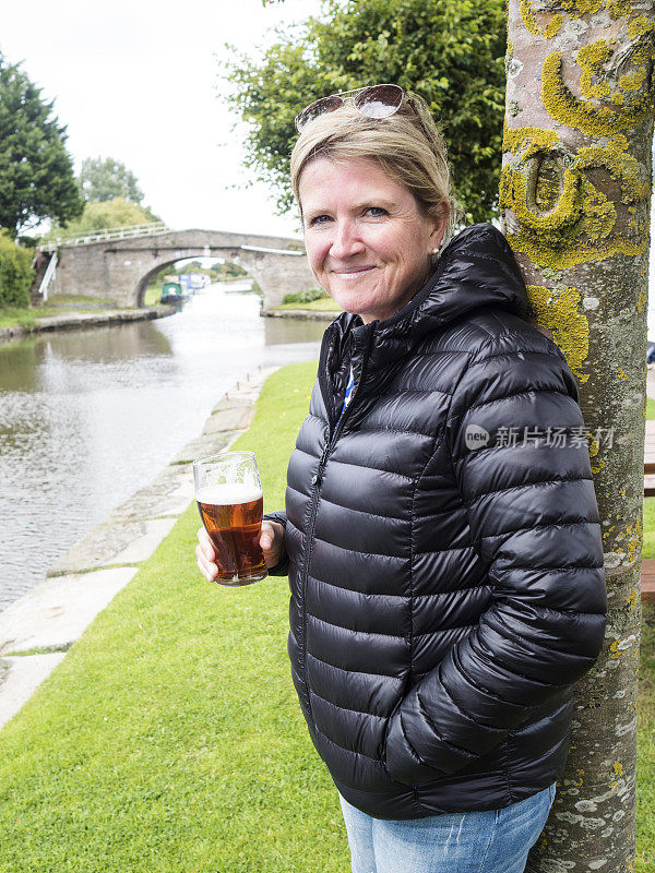 中年妇女享受风景优美的英国啤酒