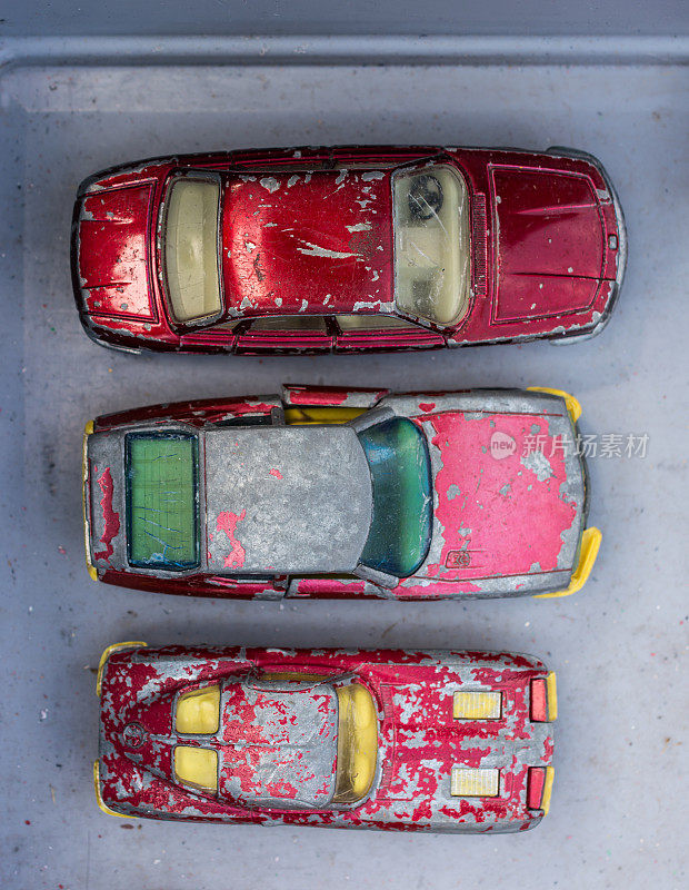 三辆红色破旧的玩具车