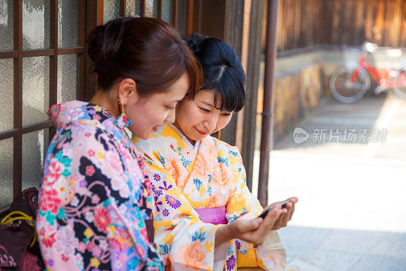 年轻的和服女孩一起看智能手机屏幕