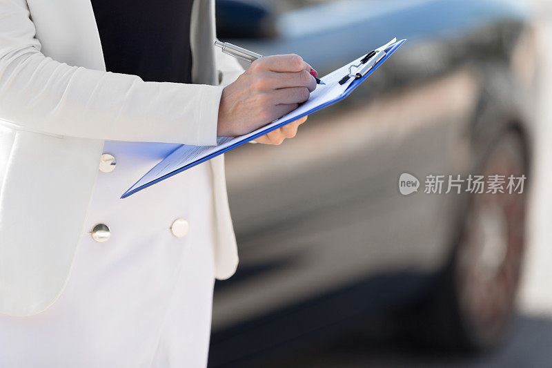 年轻女子汽车租赁检验员填写合同