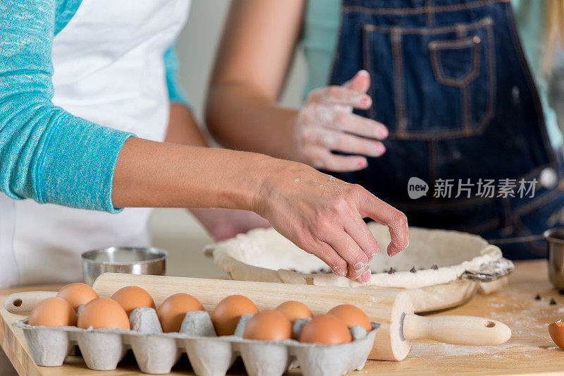 母亲和女儿用面团烤馅饼