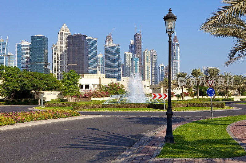 迪拜，阿联酋-灯柱，环岛，喷泉和塔。