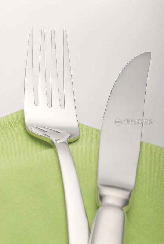 刀叉放在绿色的餐巾上