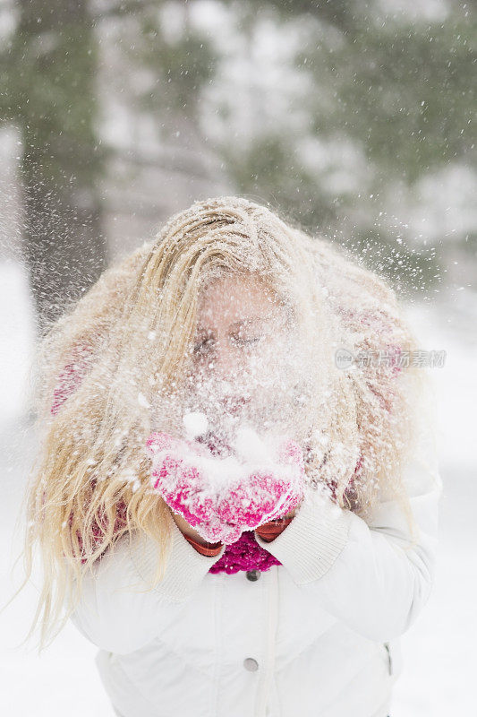 女孩从手套上吹雪