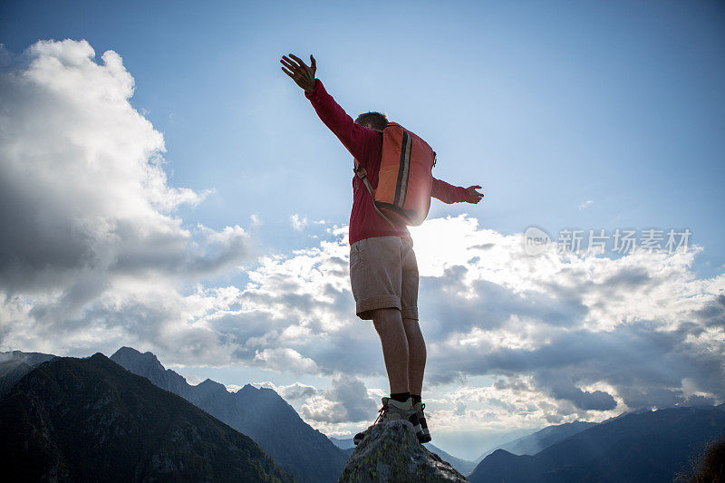 无忧无虑的徒步旅行者在山顶上找到了自由