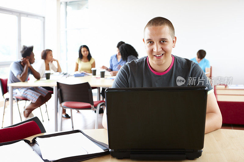 年轻的男学生在用笔记本电脑工作
