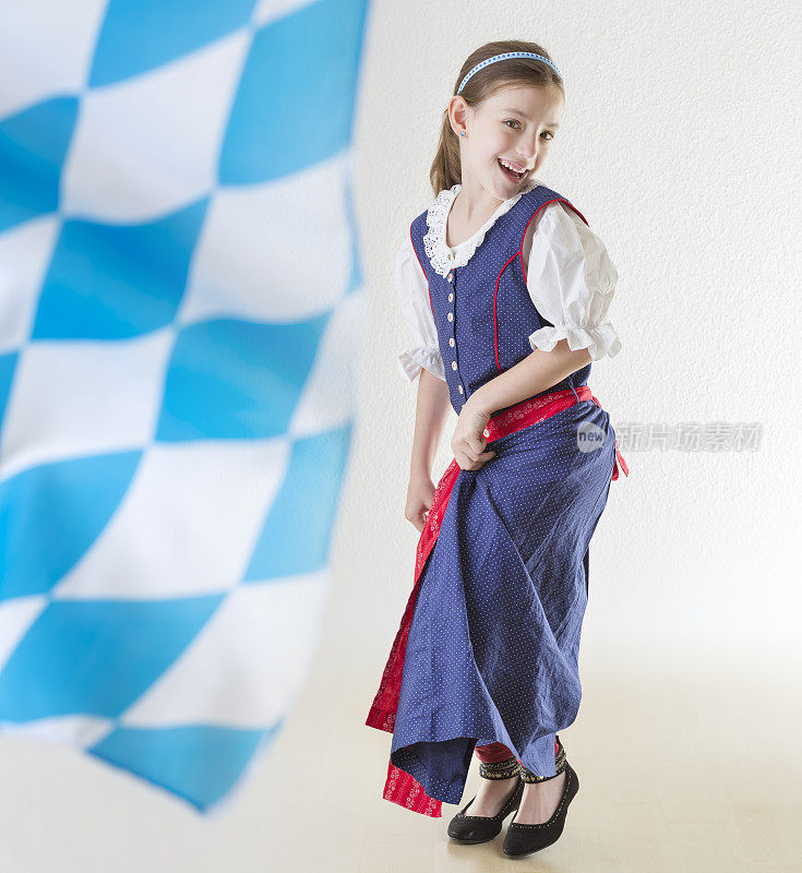 身着传统连衣裙的巴伐利亚小女孩和巴伐利亚国旗舞