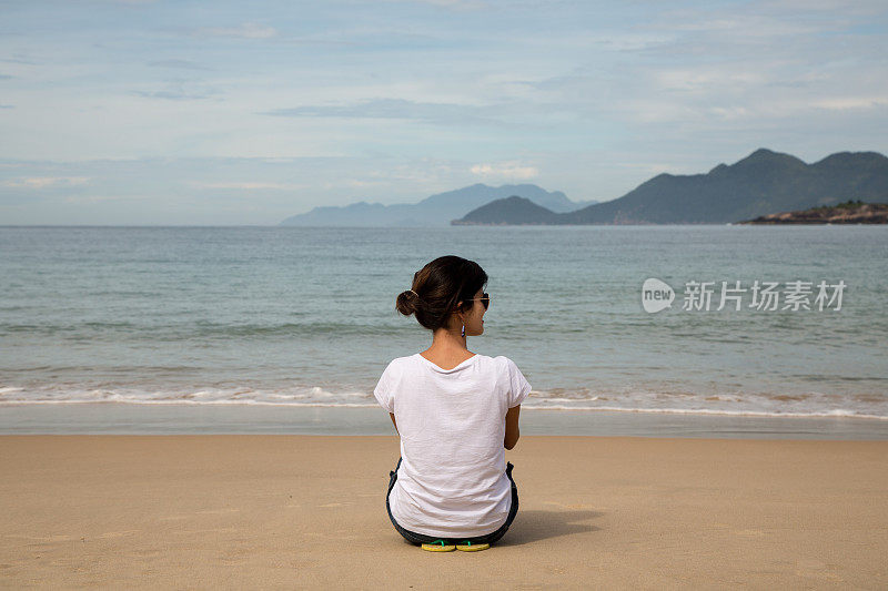 美丽的女人注视着平静的大海。