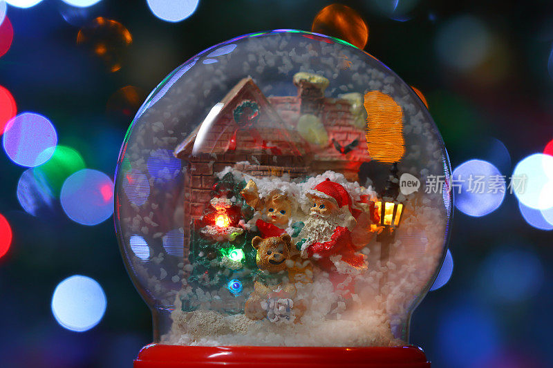 有圣诞老人的雪花玻璃球和街道照明的房子附近