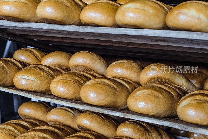 多层木架上的新鲜脆皮面包。面包店产品行业。