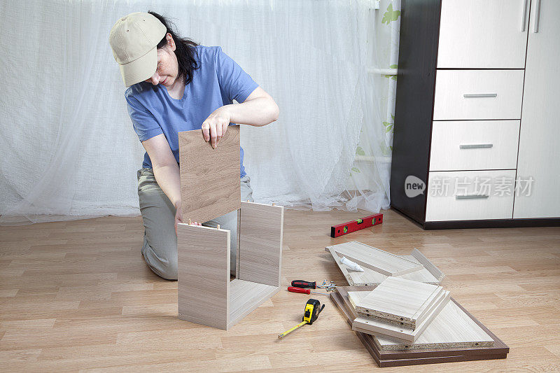 女人把硬纸板放在抽屉底部，家具组装。