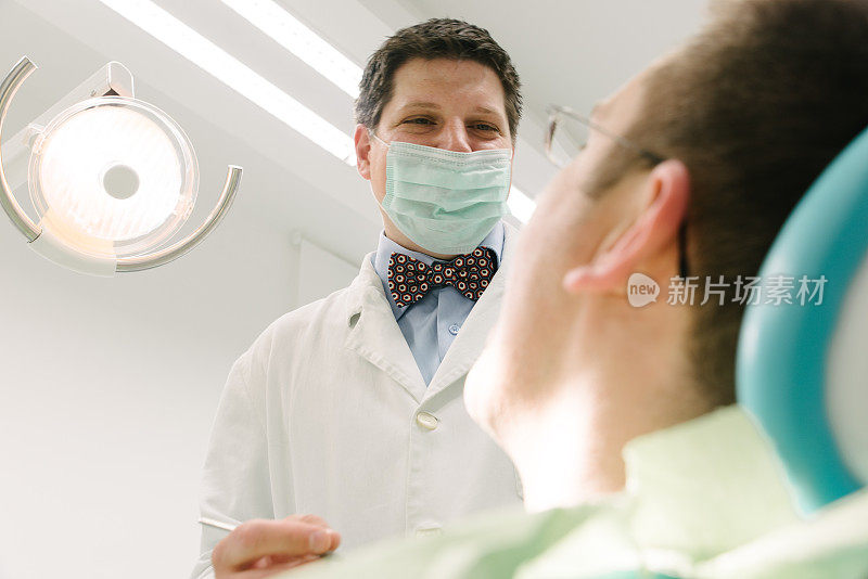 牙医对着满意的病人微笑。