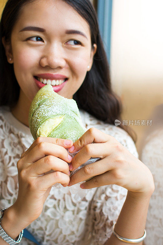 亚洲女孩吃绿茶味的面包