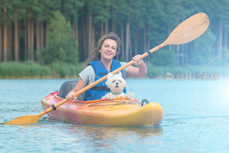 一个女人和她的狗在皮划艇上