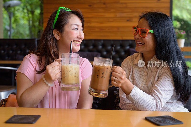 成熟的亚洲女性朋友在咖啡店闲逛的肖像