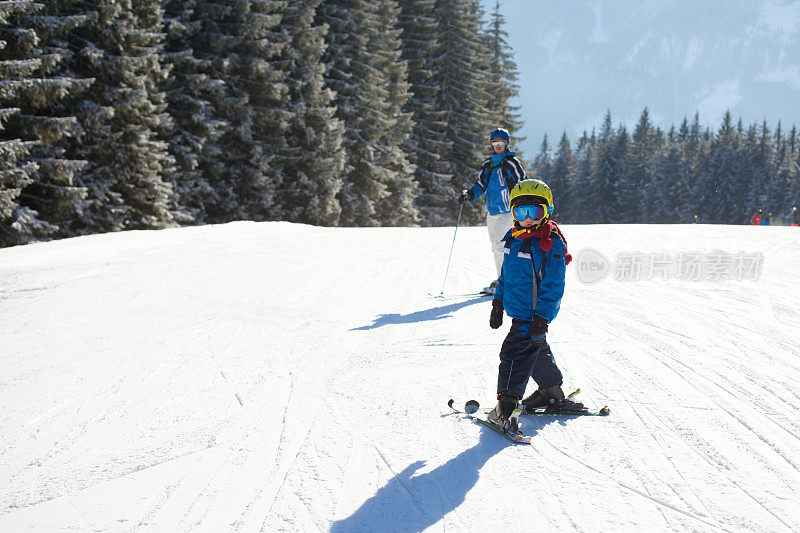可爱的小男孩，在奥地利滑雪胜地的山上愉快地滑雪