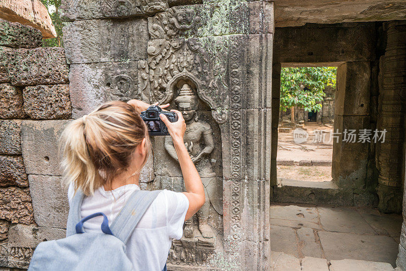女游客拍摄古庙和古庙雕刻