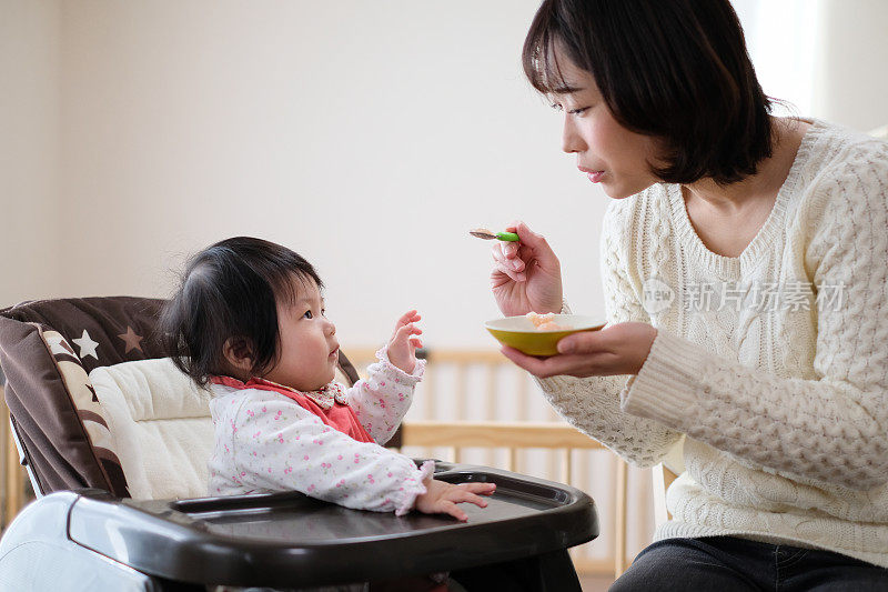 母亲给婴儿喂食物