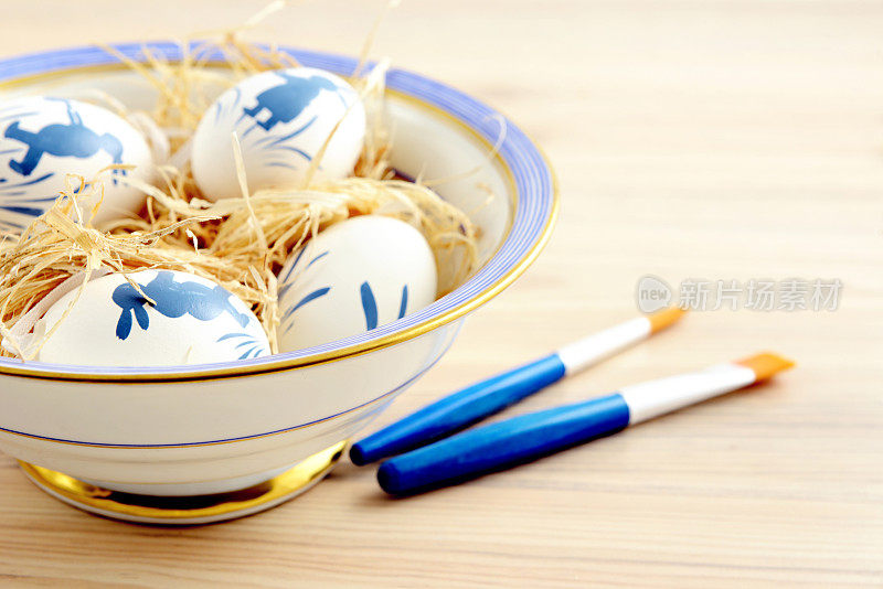把复活节彩蛋放在碗里。油漆刷一边。复活节快乐。