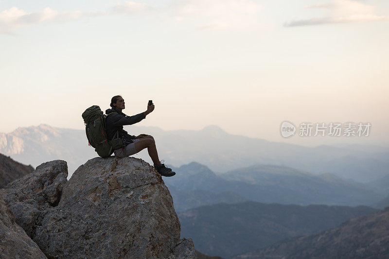 登山者在山顶使用智能手机