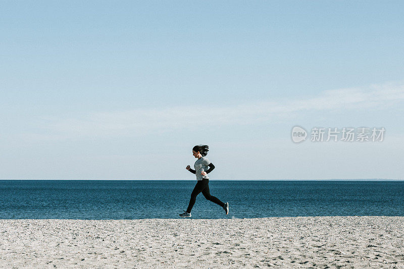 冬天在海滩上跑步的女人