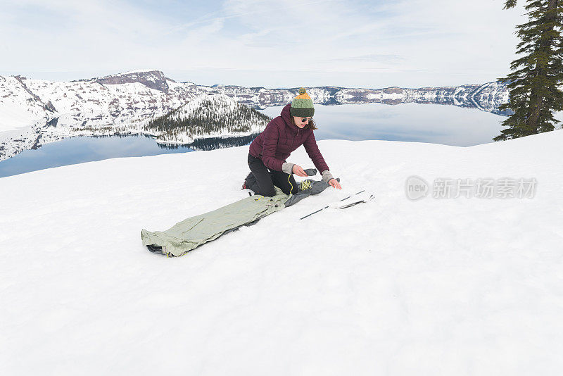 一个冬天的徒步旅行者在雪地里搭起了帐篷，俯瞰着一个湖