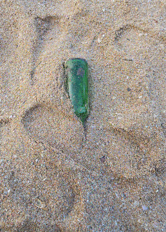海滩上的垃圾，瓶子里的信息，被冲到沙滩上的绿色玻璃瓶，危险的危险