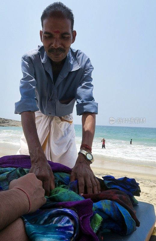 图为印度南部喀拉拉邦Kollam海滩上，当地印度男子在出售围巾和羊绒