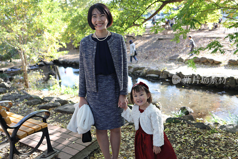 日本母亲与她的女儿走在志一去桑庆祝