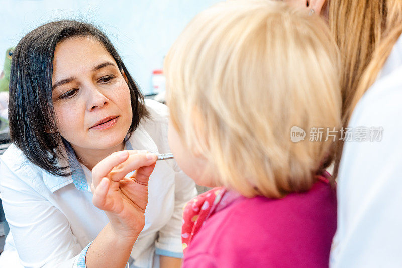 看着镜子里的小孩正在接受牙医的治疗