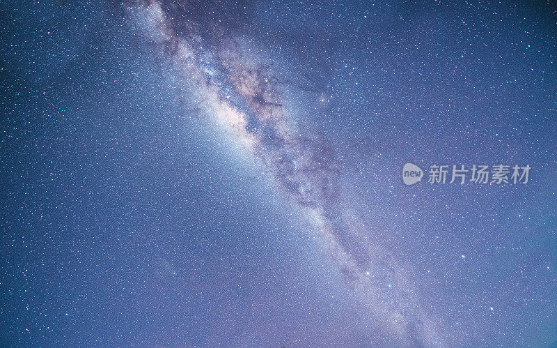 山上有银河和粉红的光。晚上多彩的景观。夏天的星空和山峦。美丽的宇宙。太空背景与星系。旅游的背景