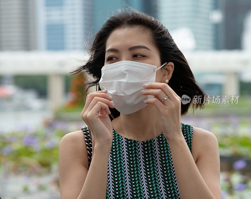 概念、疾病、病毒、过敏、空气污染。
一幅沉思的亚洲妇女的肖像，戴着防护面具，走在城市里