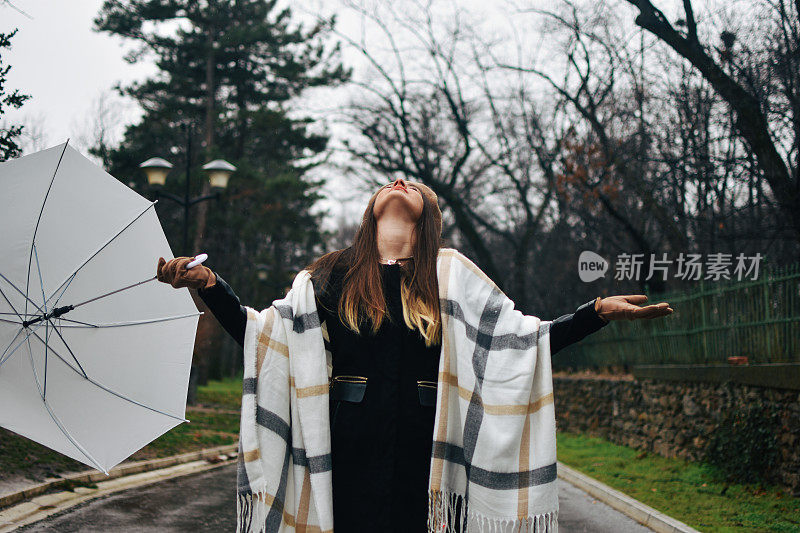 美丽的年轻女子享受着雨天