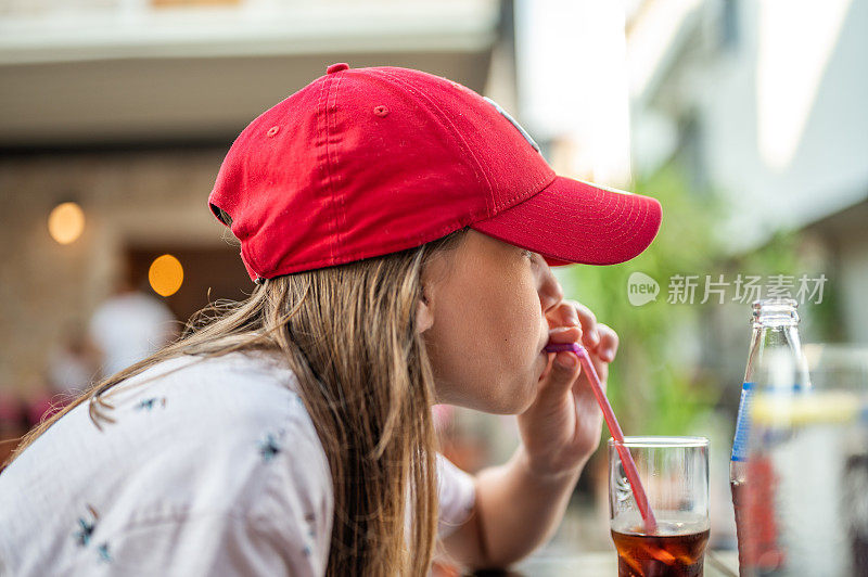 年轻女孩喝着玻璃杯里的苏打水