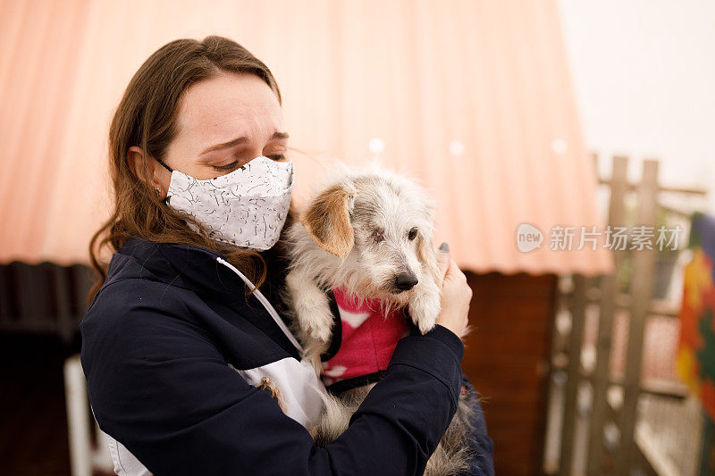 在宠物收养活动中，一个激动的女人抱着一只独眼狗