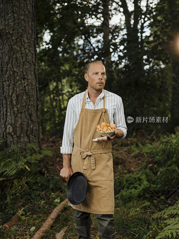 男男厨师在户外用鸡油菌和煎锅