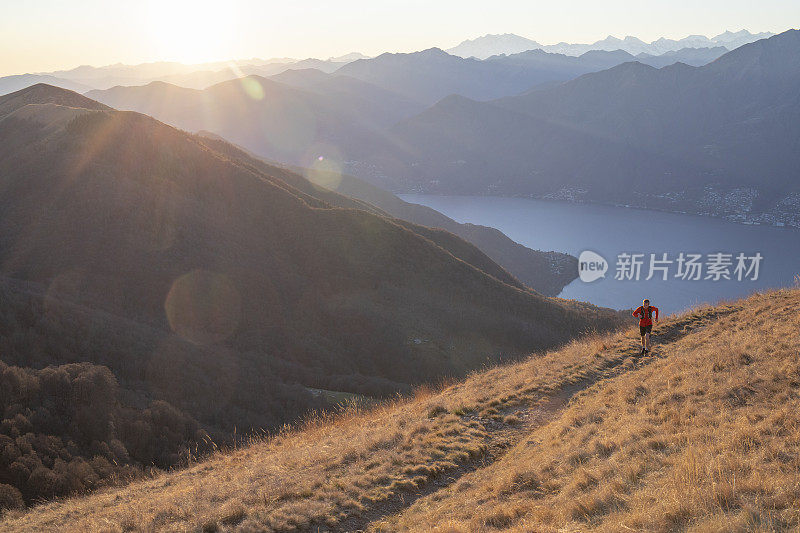 日出时，年轻人的步道跑上长满青草的山脊