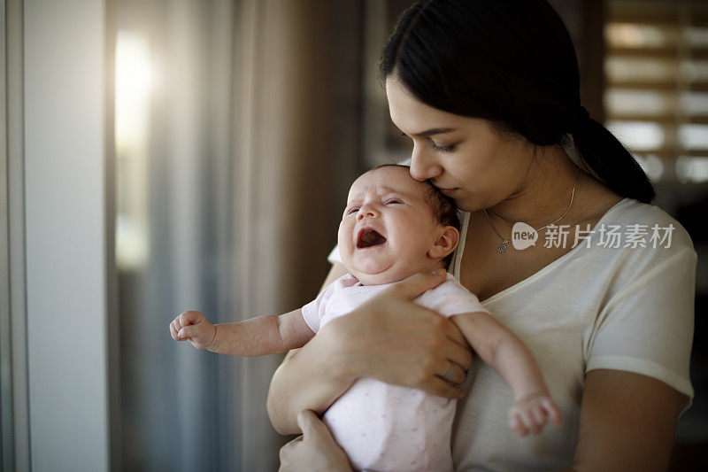 新生婴儿在妈妈的手中哭泣