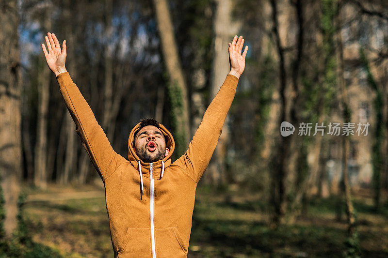 年轻人在公园里伸伸胳膊呼吸新鲜空气