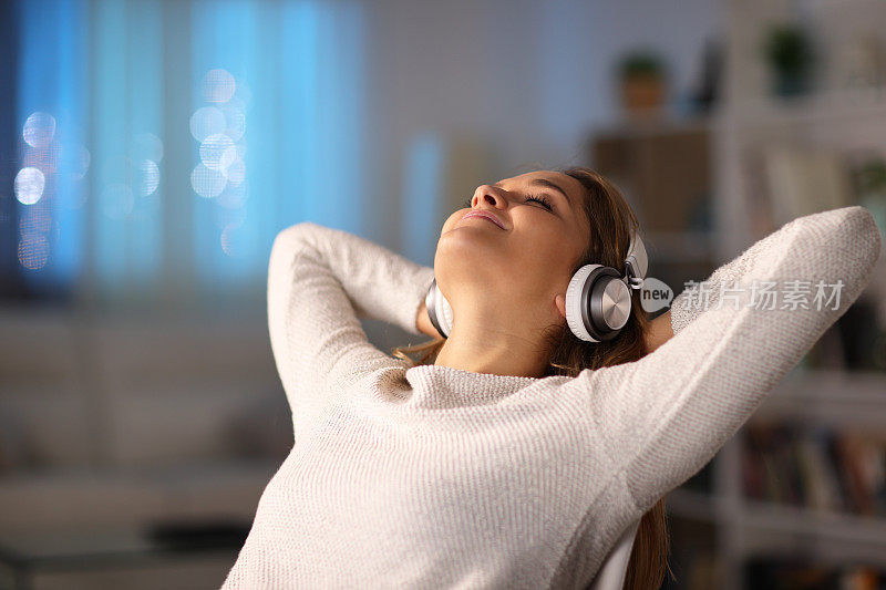 放松的女人戴着耳机听音乐
