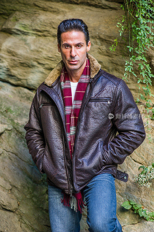 一幅中年男子站在户外岩石旁的画像