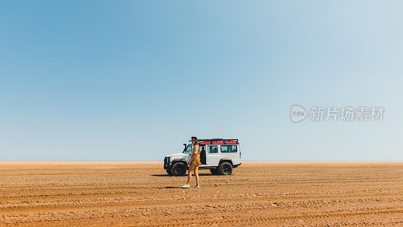 年轻女子探索野外沙丘海岸的三明治港汽车在纳米比亚