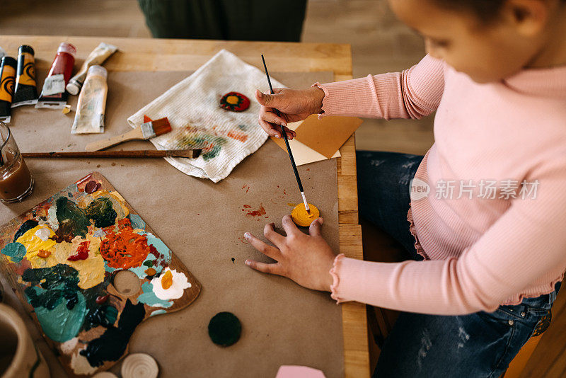 女孩在家里用水彩画画小木头