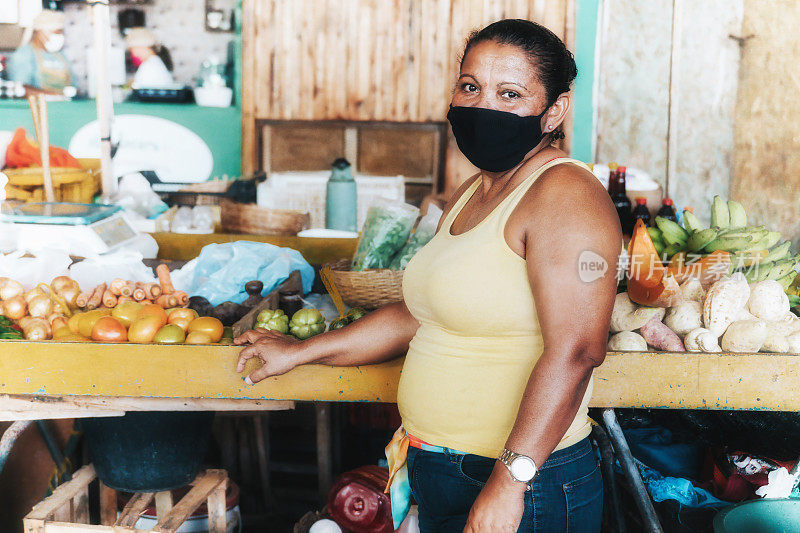 公众街市女小贩在菜摊前的肖像