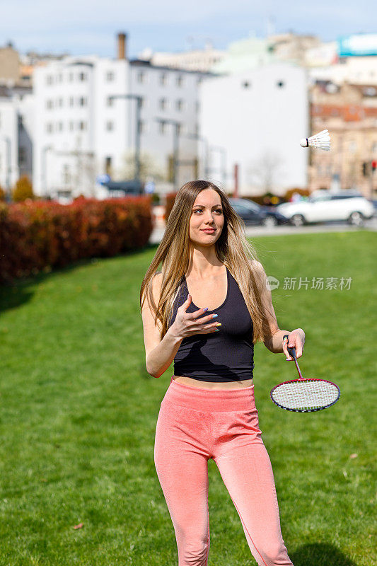 一位女运动员拿着羽毛球拍的照片。