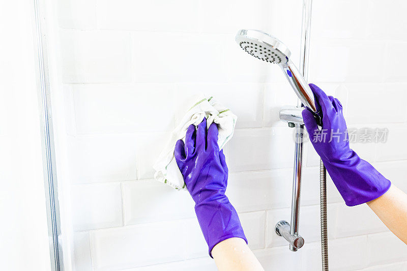 女人戴着手套用手清洁淋浴间