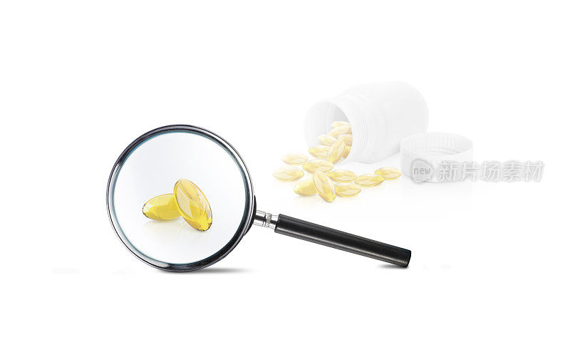 胶囊与黄色药物和一个放大镜在白色的背景。药物疗效的研究和试验。寻找必要的药品。实验室