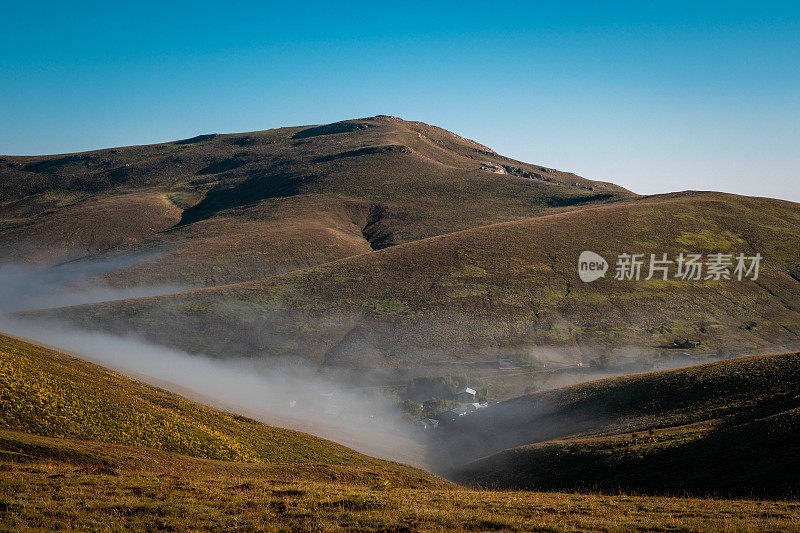 绿色的草地，雾蒙蒙的低地，山脉景观