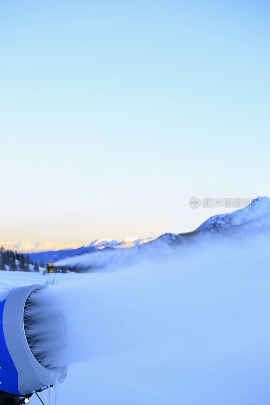 用造雪枪造雪。滑雪坡人工下雪。滑雪场配雪炮造雪机。美丽的冬季自然。山顶上的新雪。高山景观滑雪场。