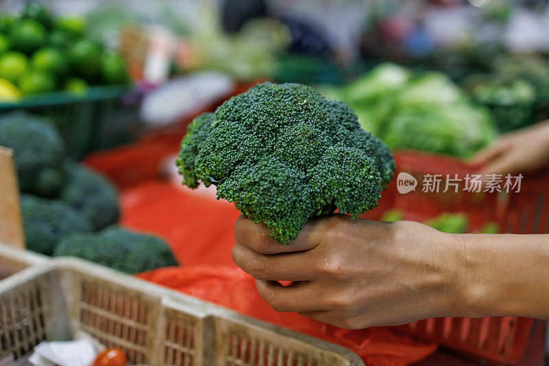 顾客在杂货店选择西兰花近距离